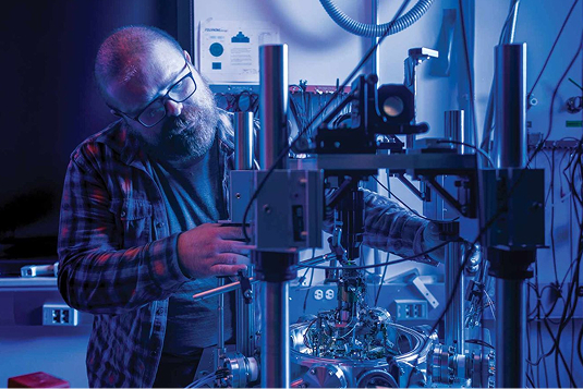 Man with beard looking closely at semiconductor