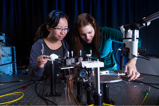 Two women working together in front of a semiconductor