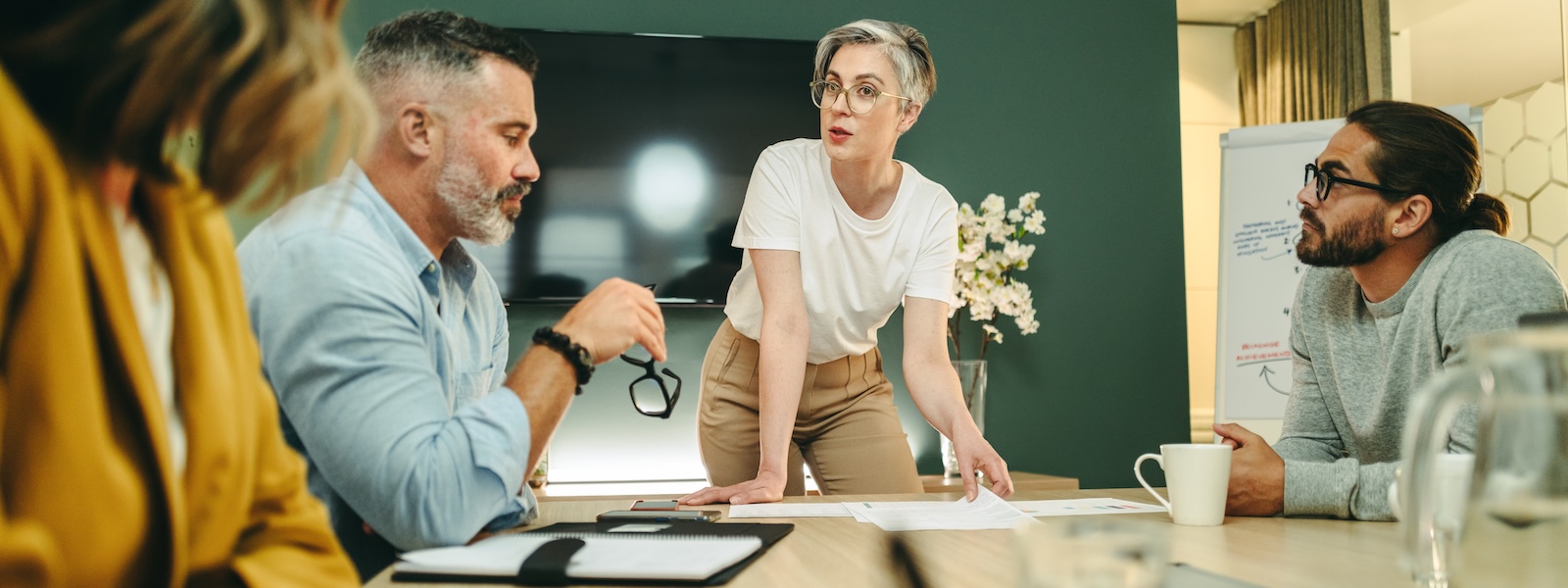 a diverse group of tech leaders at a table making critical decisions.
